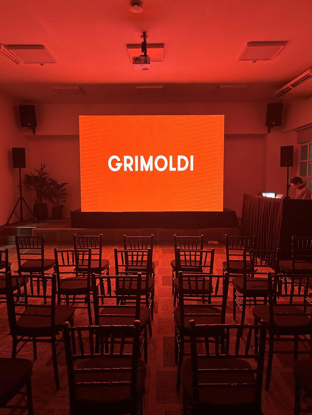 Presentación de Grimoldi con pantalla LED y sala iluminada en rojo