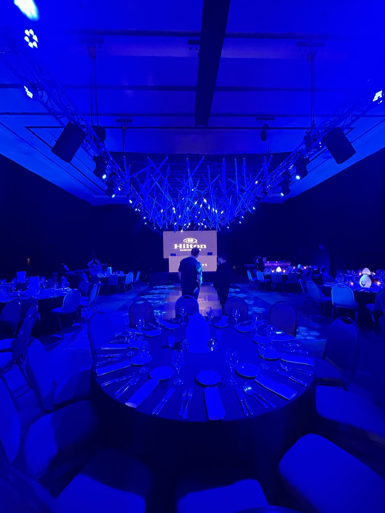 Mesas de una cena de gala en el Hilton con iluminación azul