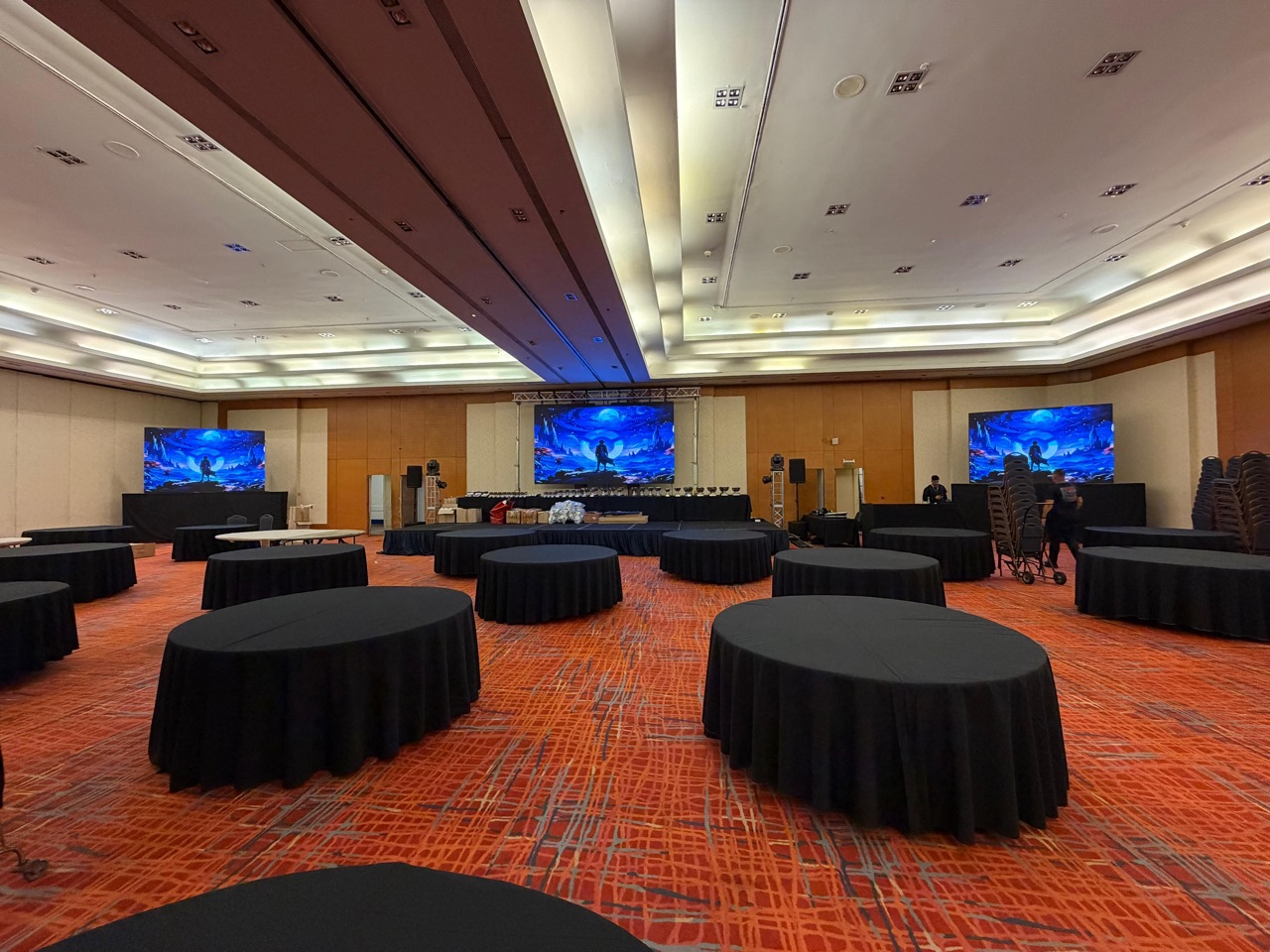 Salón de convenciones con mesas y pantallas