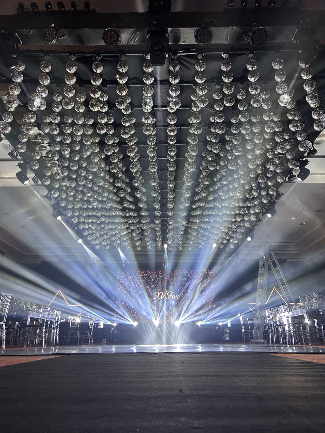 Techo cubierto de luces colgantes y haces de luz sobre la pista